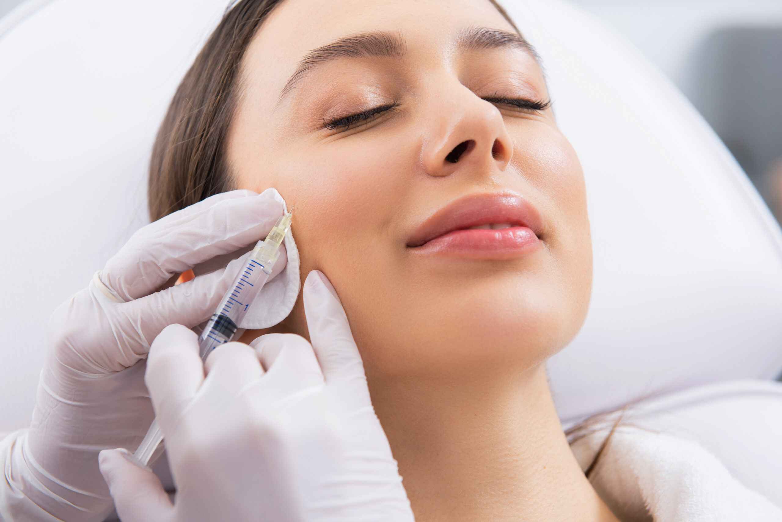 Young lady on procedure of cheek zone in salon Services Derm of Cape Cod